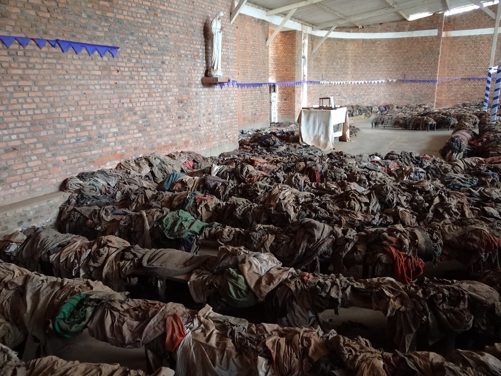 Victims’ clothing covers the pews of Nyamata church. During the genocide, ethnic discrimination and extremist propaganda promoted the extermination of Tutsi people, including those seeking sanctuary.